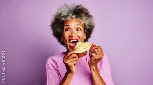 Senior lady savors a delightful pizza slice.