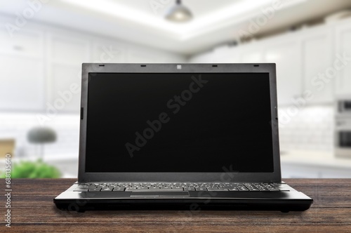 Modern laptop with black blank screen on desk