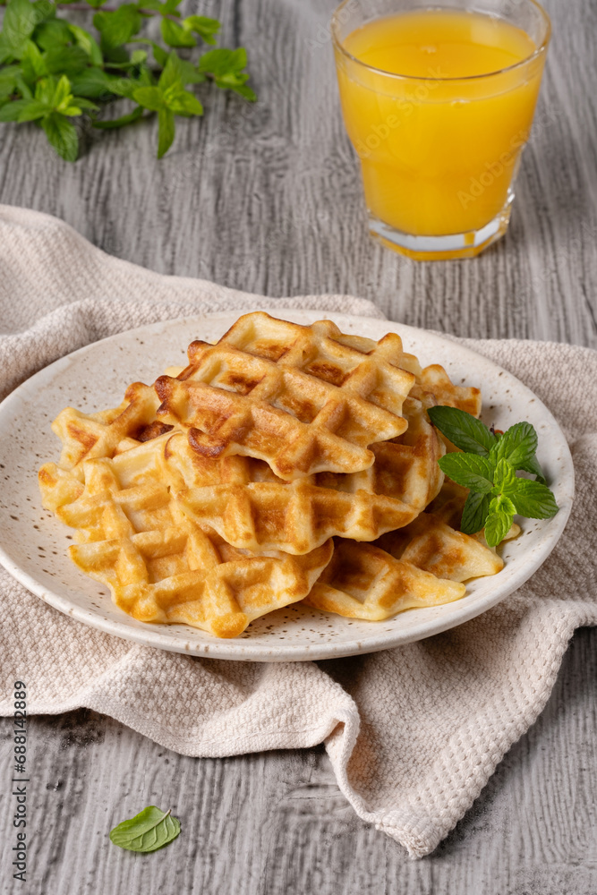 Waffles paired with a glass of freshly squeezed orange juice Waffles paired with a glass of freshly squeezed orange juice