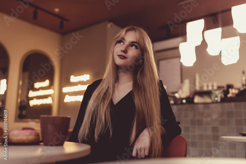 Portrait of a young beautiful blonde girl in a cafe.