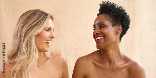 Beauty Portrait Of Two Smiling Mature Women With Bare Shoulders Against Natural Background