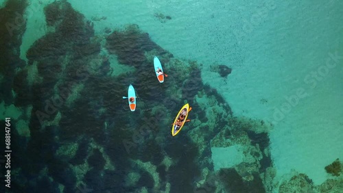 Drone top aerial view of friends with paddles and kayak on turquoise water of Mediterranean sea of Sardinia, Italy photo