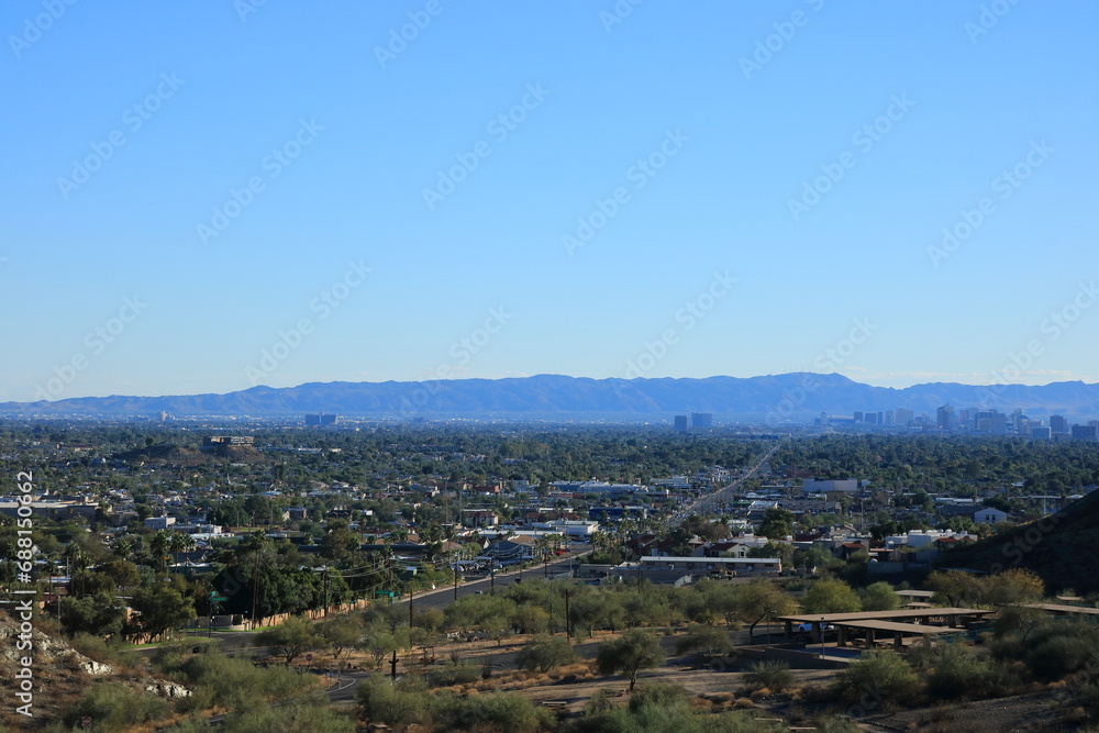 Bluish haze over Arizona Capital City of Phoenix downtown under cloudless sky as seen from North Mountain Park toward South mountains