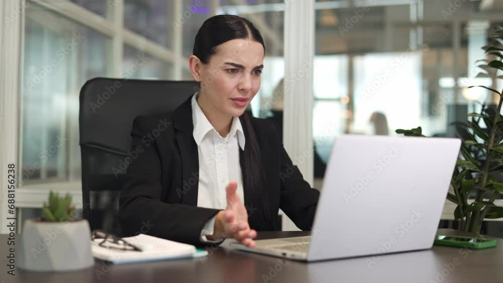 Irritated company employee typing on laptop keyboard while having problems with completing work on time. Caucasian female sitting on chair worrying and having problems with deadlines in office. Irritated company employee typing on laptop keyboard while having problems with completing work on time. Caucasian female sitting on chair worrying and having problems with deadlines in office.