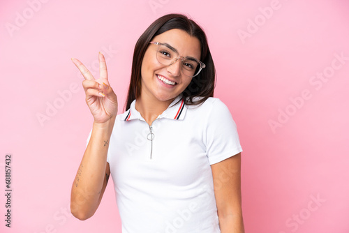 Young caucasian woman isolated on pink background With glasses and doing OK sign