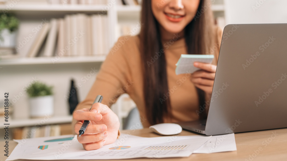 Beautiful young woman using laptop while working in home office. Businesswoman happy and smiling at indoors. Beautiful young woman using laptop while working in home office. Businesswoman happy and smiling at indoors.
