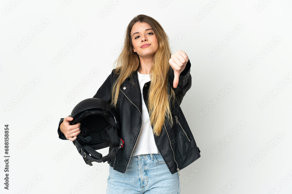 Woman holding a motorcycle helmet isolated on white background showing thumb down with negative expression Woman holding a motorcycle helmet isolated on white background showing thumb down with negative expression