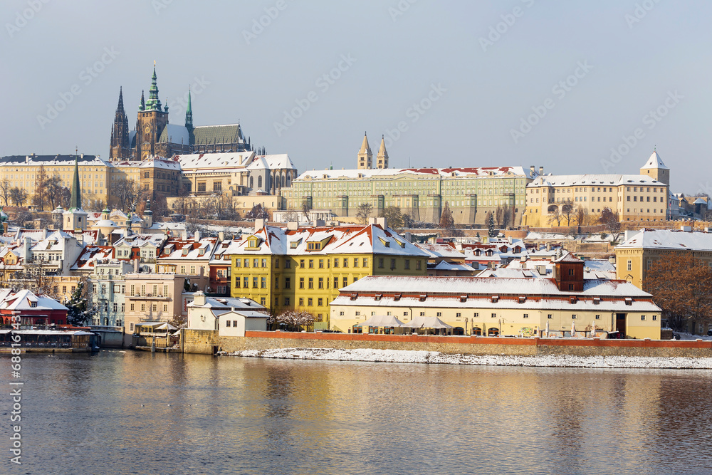 Snowy Prague Lesser Town with gothic Castle above River Vltava, Czech republic