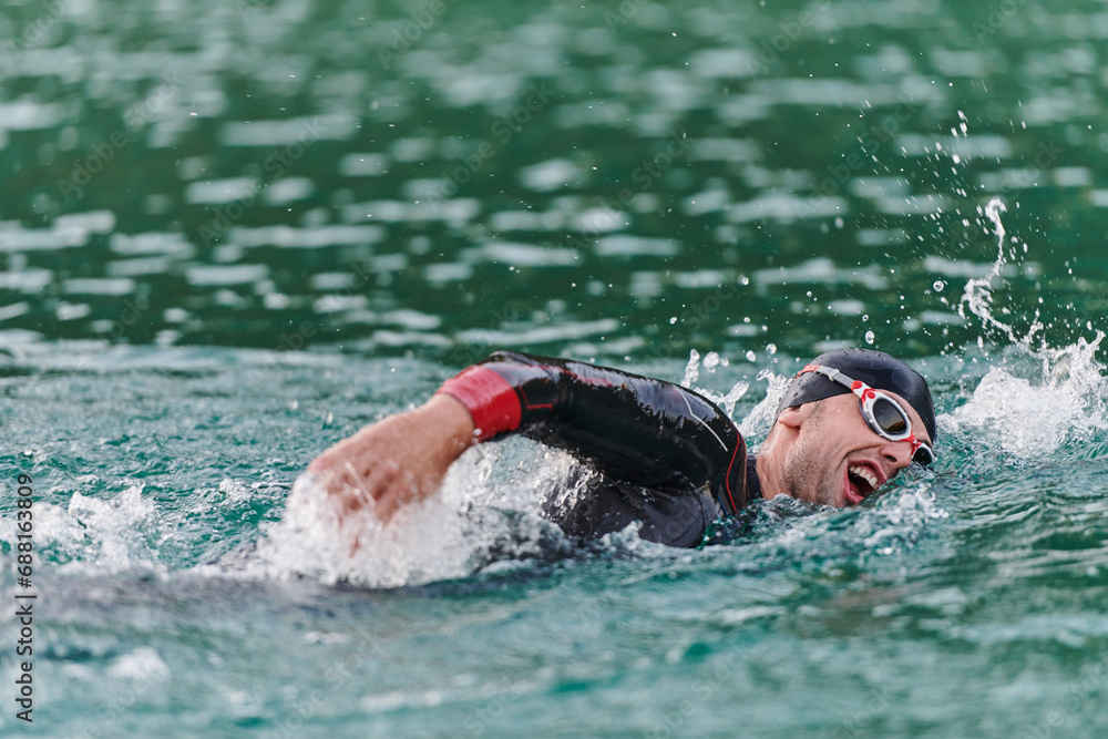 A professional triathlete trains with unwavering dedication for an upcoming competition at a lake, emanating a sense of athleticism and profound commitment to excellence.