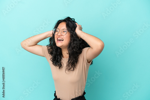 Young asian woman isolated on blue background stressed overwhelmed photo