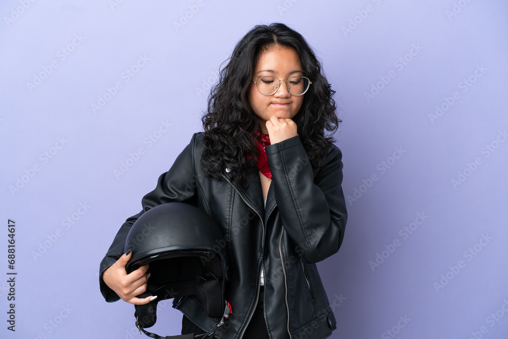 Young asian woman with a motorcycle helmet isolated on purple background having doubts Young asian woman with a motorcycle helmet isolated on purple background having doubts