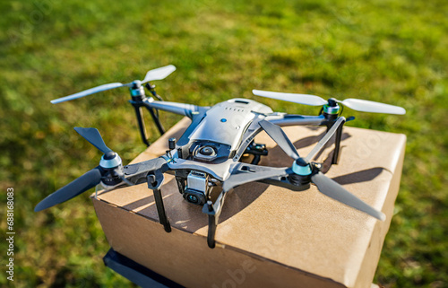 A drone descends over a field to deliver packages. Close-up view. photo