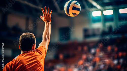Male volleyball player reaching for ball with hands photo