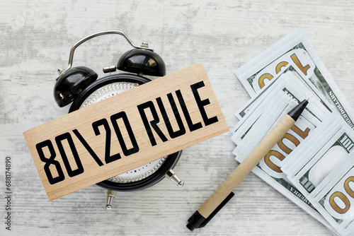 80 20 Rule money bills and pen. top view of wooden block on table clock photo