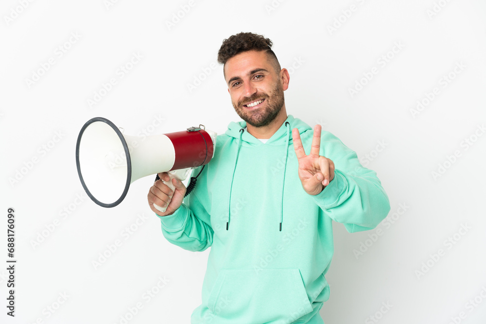 Caucasian man isolated on white background holding a megaphone and smiling and showing victory sign Caucasian man isolated on white background holding a megaphone and smiling and showing victory sign