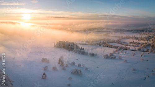 Sunset over the low hanging clouds and the beautiful winter landscape photo