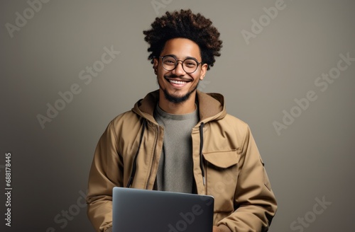 young man holding a laptop and smiling,