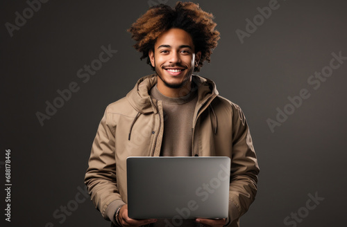 young man holding a laptop and smiling,