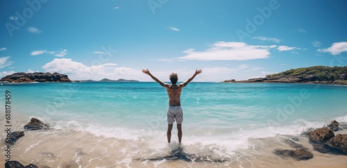 young man standing by the beach with arms wide open