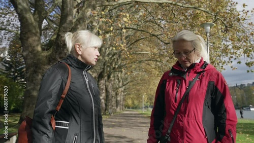 Senior Caucasian Sisters in Autumn Park Discussing and Arguing. Granny pissed off. Disputing, argument, controversy