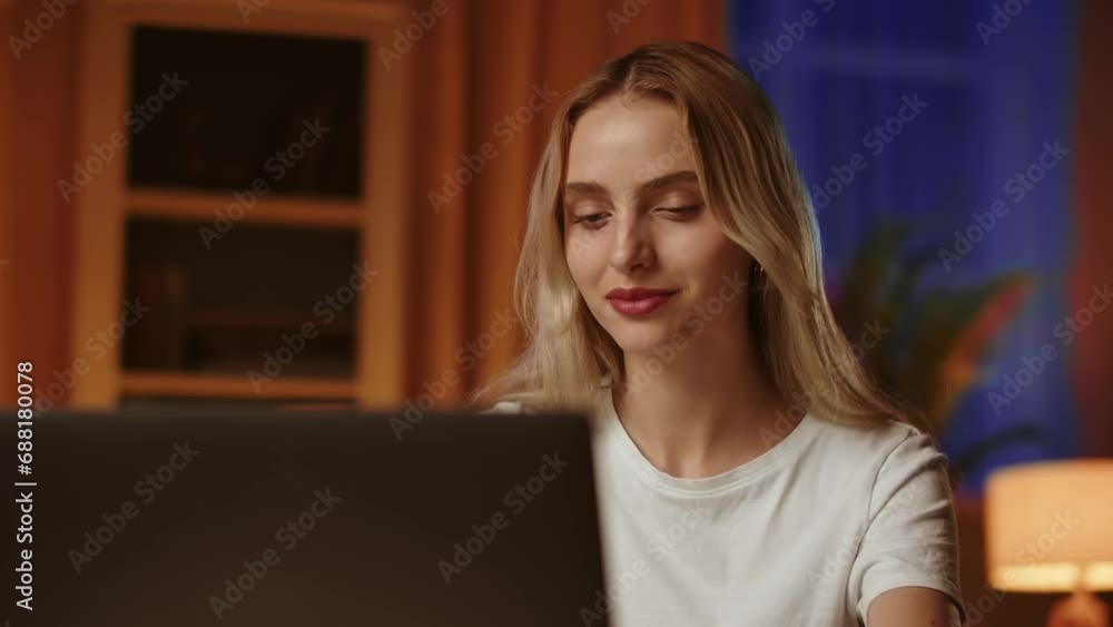 A smiling blonde student girl in a great mood uses laptop, messages with a friend about the upcoming holidays and meeting after the summer session exams. A friendly young lady blogger chats nicely A smiling blonde student girl in a great mood uses laptop, messages with a friend about the upcoming holidays and meeting after the summer session exams. A friendly young lady blogger chats nicely