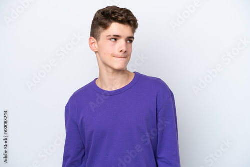 Teenager Russian man isolated on white background having doubts while looking up