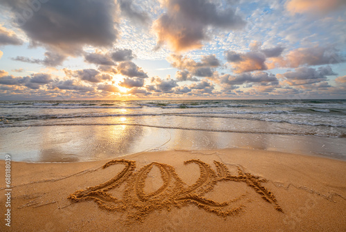 Fototapeta Naklejka Na Ścianę i Meble -  Happy New Year 2024 ocean sunrise on the beach. Written text on the sea beach at sunrise.