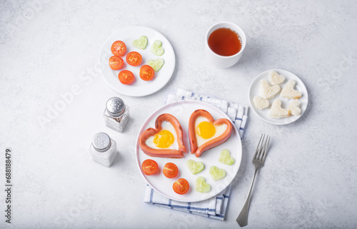 Fresh breakfast with fried sausage with fried egg in the form of heart for Valentine's day holiday