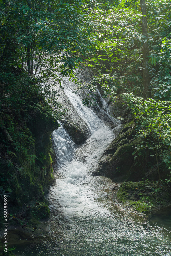 Erawan National Park in Thailand. Erawan Waterfall is a popular tourist destination and famous for its emerald blue water. Deep forest in tropical climate with fantasy atmosphere. Erawan National Park in Thailand. Erawan Waterfall is a popular tourist destination and famous for its emerald blue water. Deep forest in tropical climate with fantasy atmosphere.