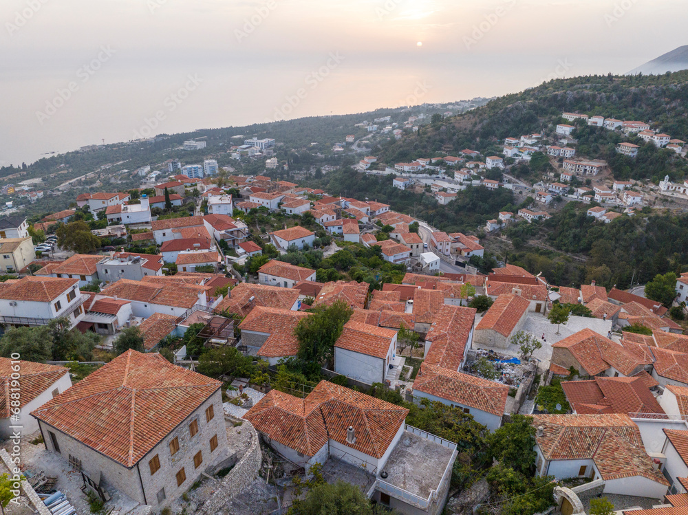 Dhermi at Sunset time. Aerial Shot of Beautiful Village Sea View, Stone Houses, beach Resort in Mountains of Albania