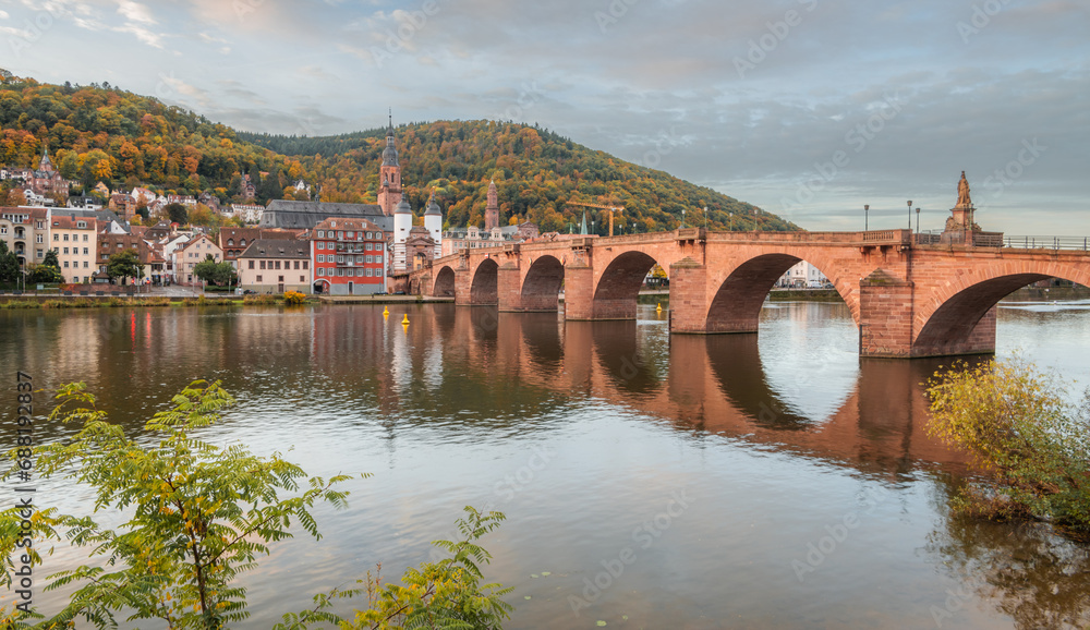 View on the Karl Theodor Bridge (German: Karl-Theodor-Brücke) and the old gate in the german city Heidelberg during early morning on a cloudy day. Heidelberg on Neckar river.