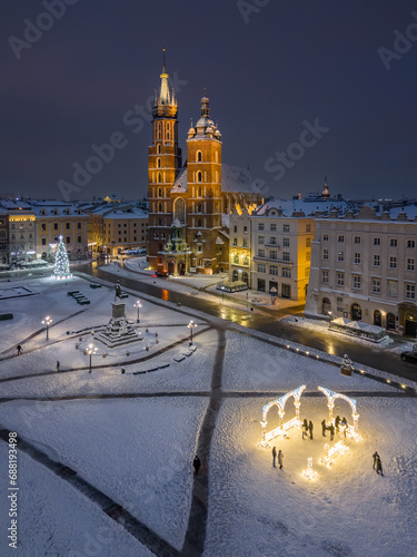 St Mary's church and Christmas tree on the snow covered Main Square in the winter night, Krakow, Poland
