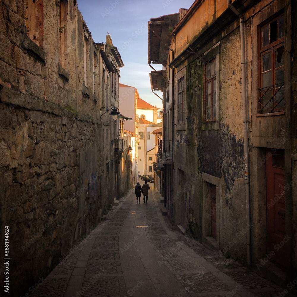 Obraz premium Couple walking down the narrow street in Porto, Portugal, January 2019
