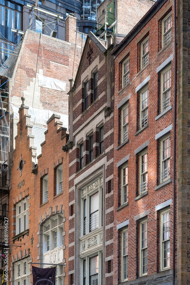 New York City, NY, USA, Low angle view of some of the historic buildings on Stone Street of former New Amsterdam in Manhattan with modern high rise in the background
