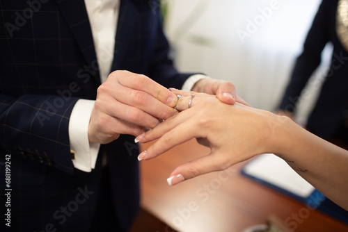 Pan Młody zakłada obrączkę na palec. The groom puts the ring on his finger.  © Szymon Korta