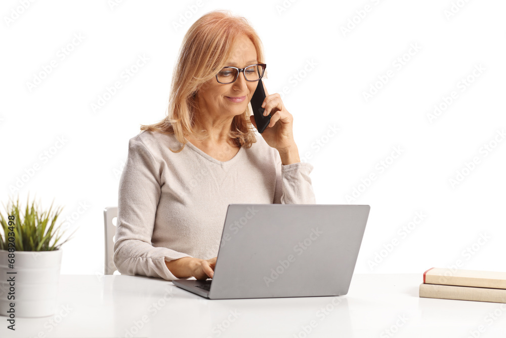 Middle age woman working on a laptop computer and using a smartphone Middle age woman working on a laptop computer and using a smartphone