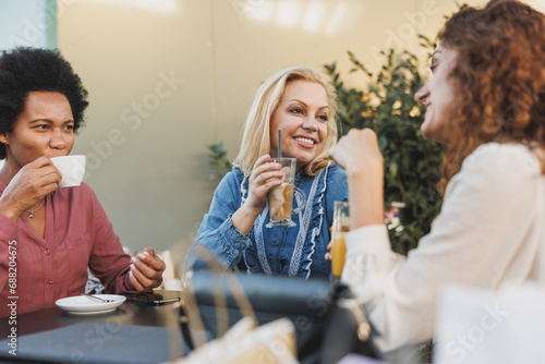 A Group Of Women Sitting In Cafe With Drinks And Sharing A Laugh