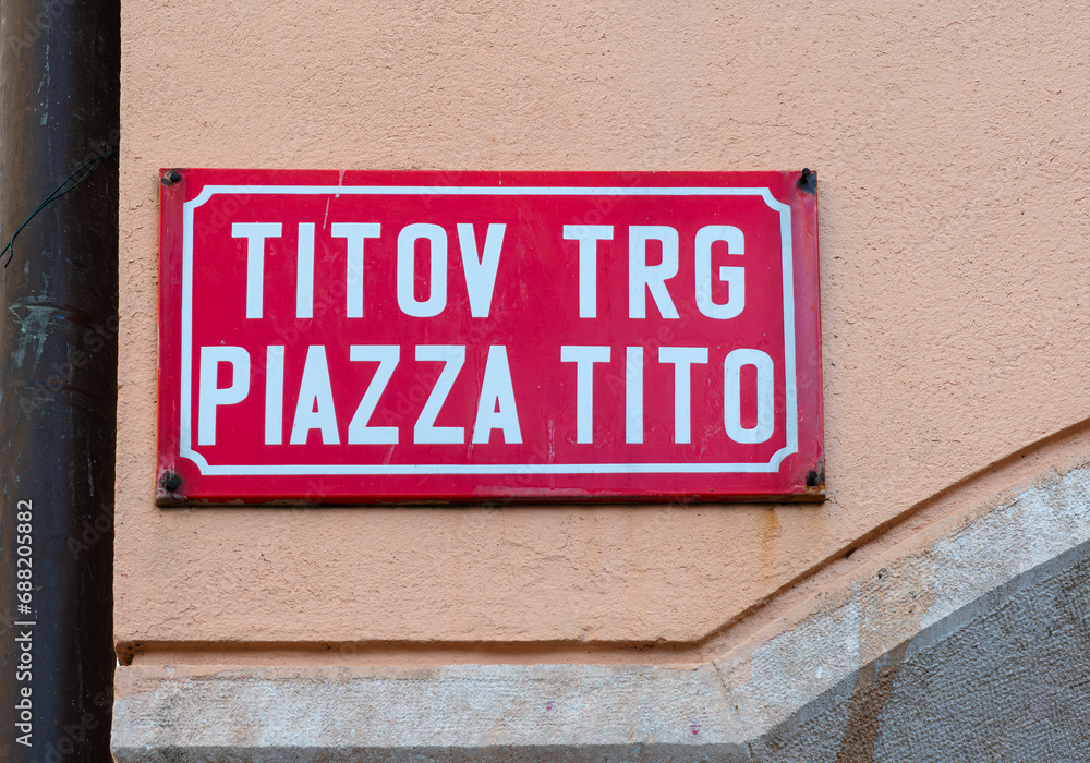 Koper, Slovenia - November 8, 2023: Bilingual slovenian and italian name of the Tito square in Koper, Slovenia, dedicated to the ex-yugoslav dictator. - obrazy, fototapety, plakaty 