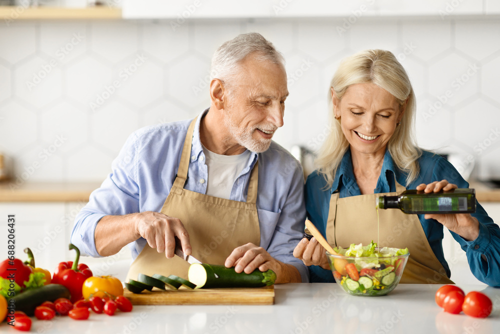 Joyful elderly couple enjoying cooking together in home kitchen Joyful elderly couple enjoying cooking together in home kitchen