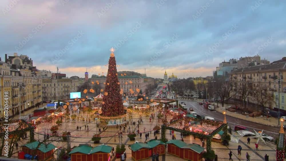 An enchanting aerial view of the Christmas Market at Sophia Square in Kyiv, Ukraine. The setting sun casts a warm glow on the bustling market and the towering Christmas tree An enchanting aerial view of the Christmas Market at Sophia Square in Kyiv, Ukraine. The setting sun casts a warm glow on the bustling market and the towering Christmas tree