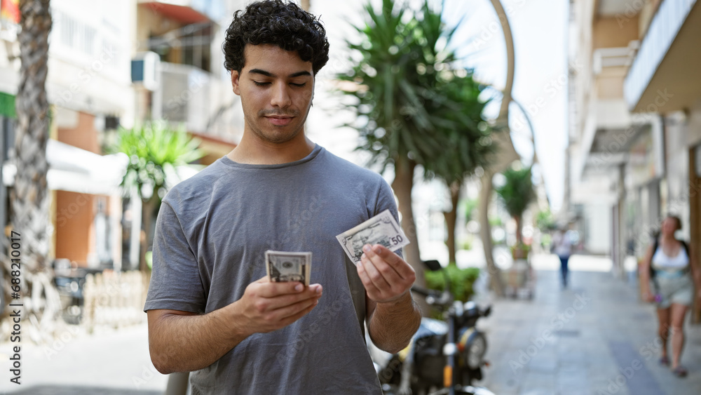 Young latin man counting dollars at street Young latin man counting dollars at street
