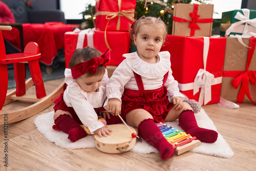 Adorable girls playing xylophone and tambourine celebrating christmas at home
