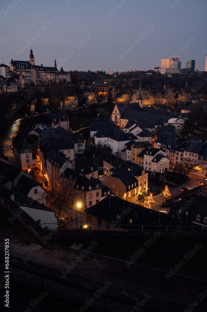 Obraz premium Night view of the picturesque old quarter of Luxembourg City with illuminated streets and historic buildings. 
