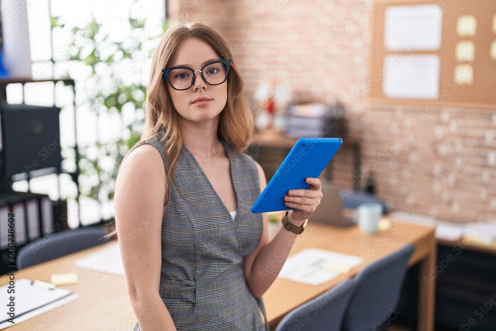Caucasian woman working at the office wearing glasses relaxed with serious expression on face. simple and natural looking at the camera. Caucasian woman working at the office wearing glasses relaxed with serious expression on face. simple and natural looking at the camera.