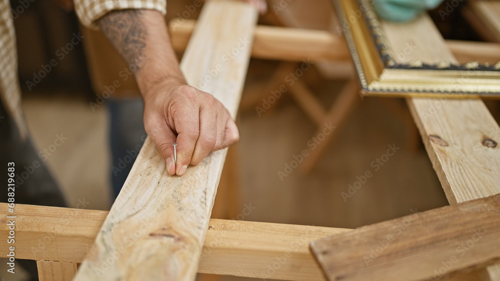 Two trusty carpenters partnering in carpentry, industriously driving a clove into a wood plank in their indoor workshop Two trusty carpenters partnering in carpentry, industriously driving a clove into a wood plank in their indoor workshop