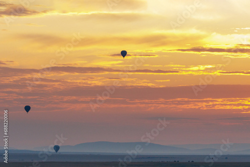 A beautiful landscape photo shot in Masai Mara Kenya  the photo also shows vast dramatic sky and balloon safari in the morning.