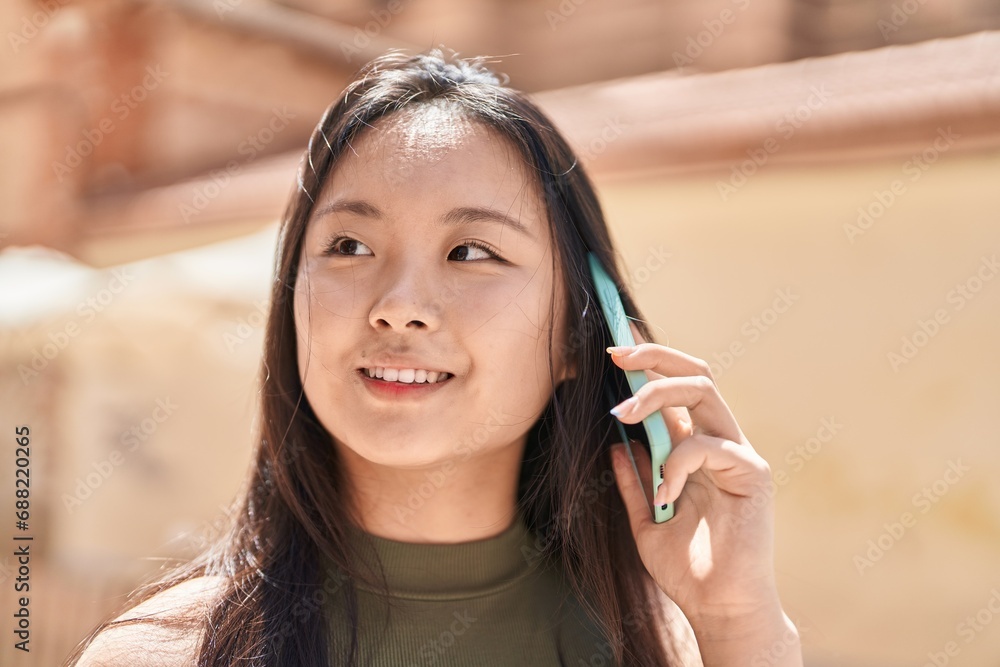 Young chinese woman smiling confident talking on the smartphone at street Young chinese woman smiling confident talking on the smartphone at street