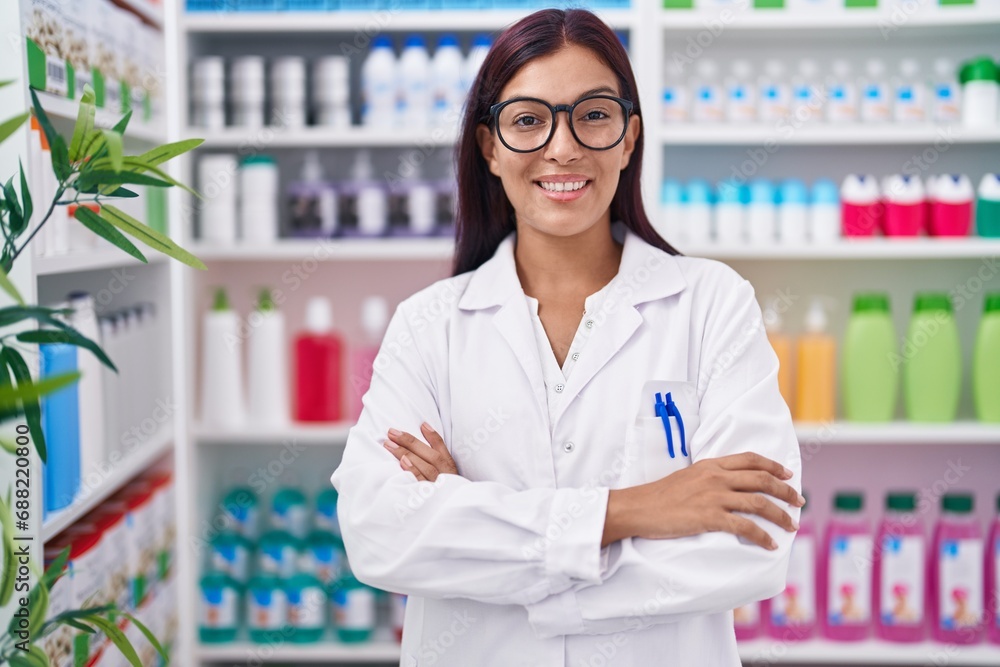 Young beautiful hispanic woman pharmacist smiling confident standing with arms crossed gesture at pharmacy Young beautiful hispanic woman pharmacist smiling confident standing with arms crossed gesture at pharmacy