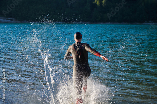 Triathlon athlete starting swimming training on lake © .shock