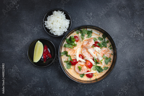 Tom yum with seafood, rice, lemon wedge and hot pepper.